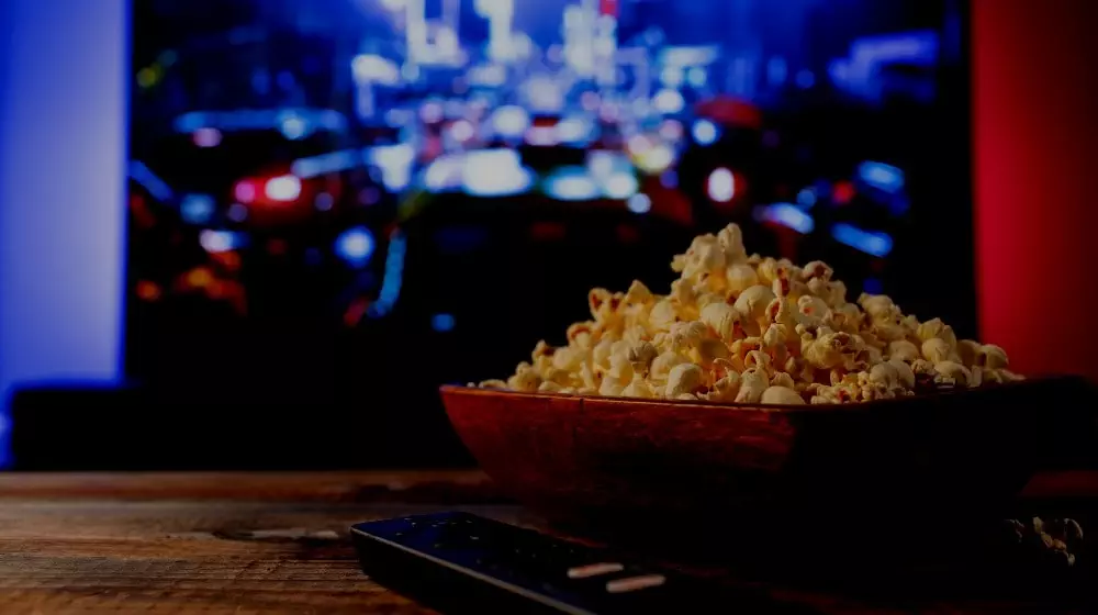 popcorn on table infront of tv playing movie